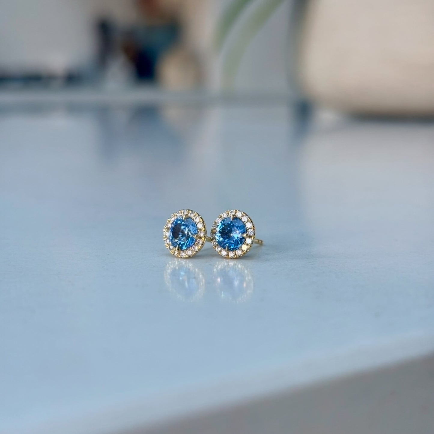 A pair of sapphire stud earrings with diamond halo in18ct gold