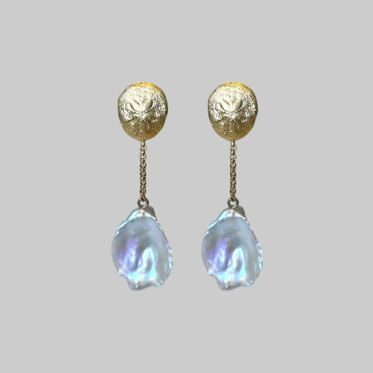 Golden sand dollar and freshwater baroque pearls earrings on a model