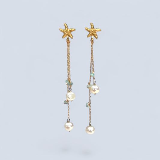 Starfish and pearl drop earrings on a light blue background