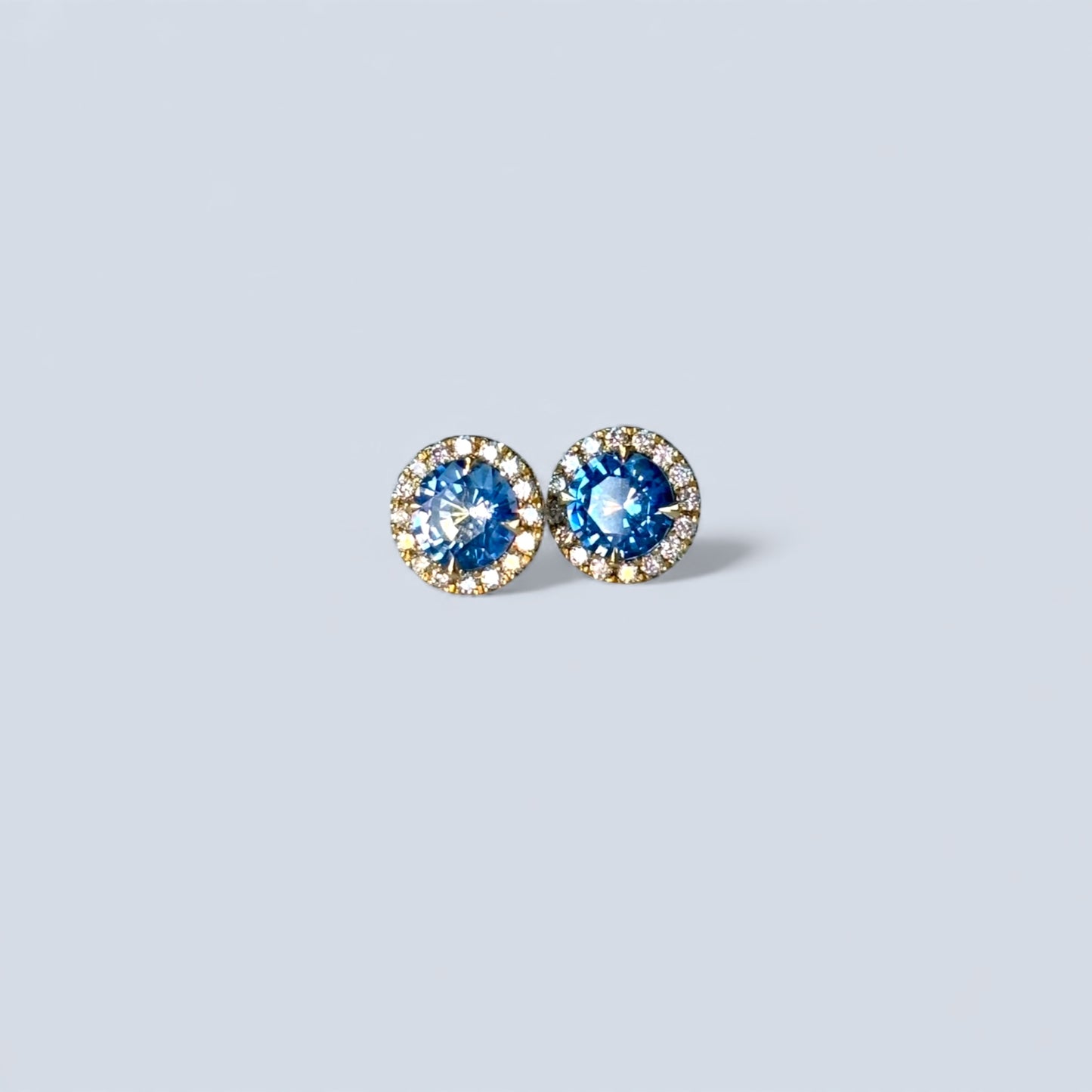 A pair of sapphire stu earrings with the diamond hallo in 18ct gold