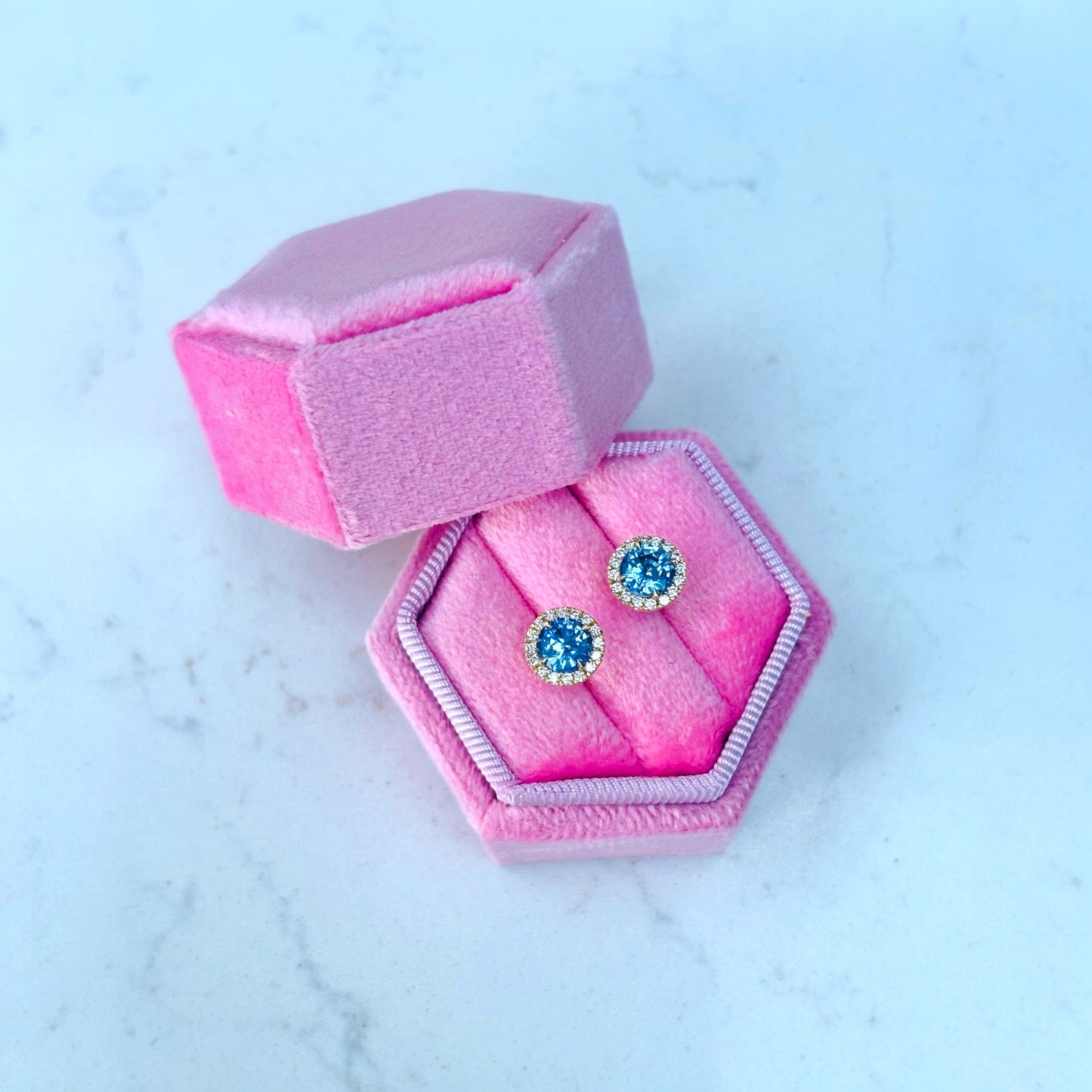 Pair of sapphire and diamonds stud earrings in a pink hexagonal gift box